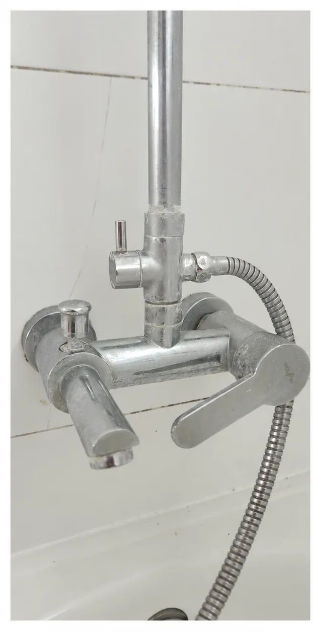 Llave cromada de ducha con depósitos blanquecinos
