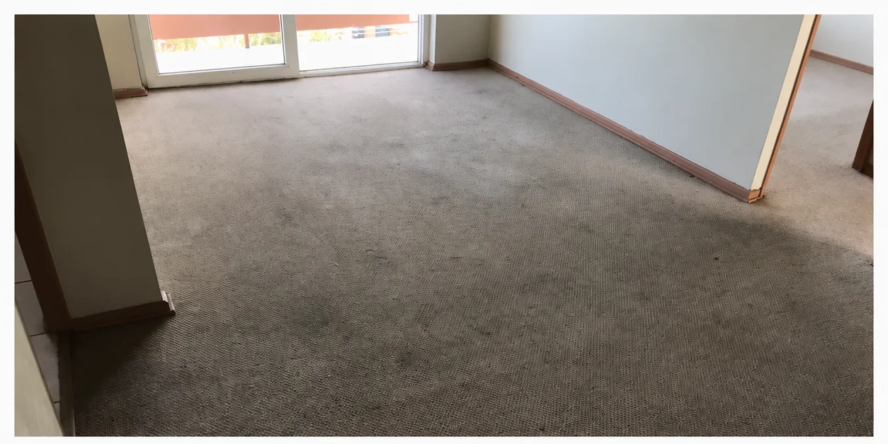 Cubrepiso gris de una habitación con zonas oscurecidas antes del lavado