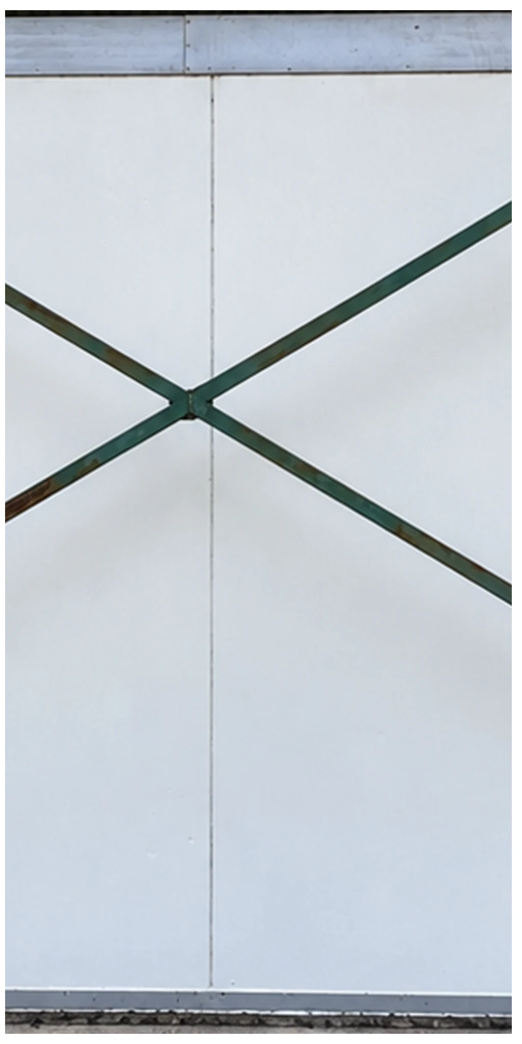 El mismo panel blanco exterior sin las manchas oscuras y verdes visibles detrás de la estructura en X