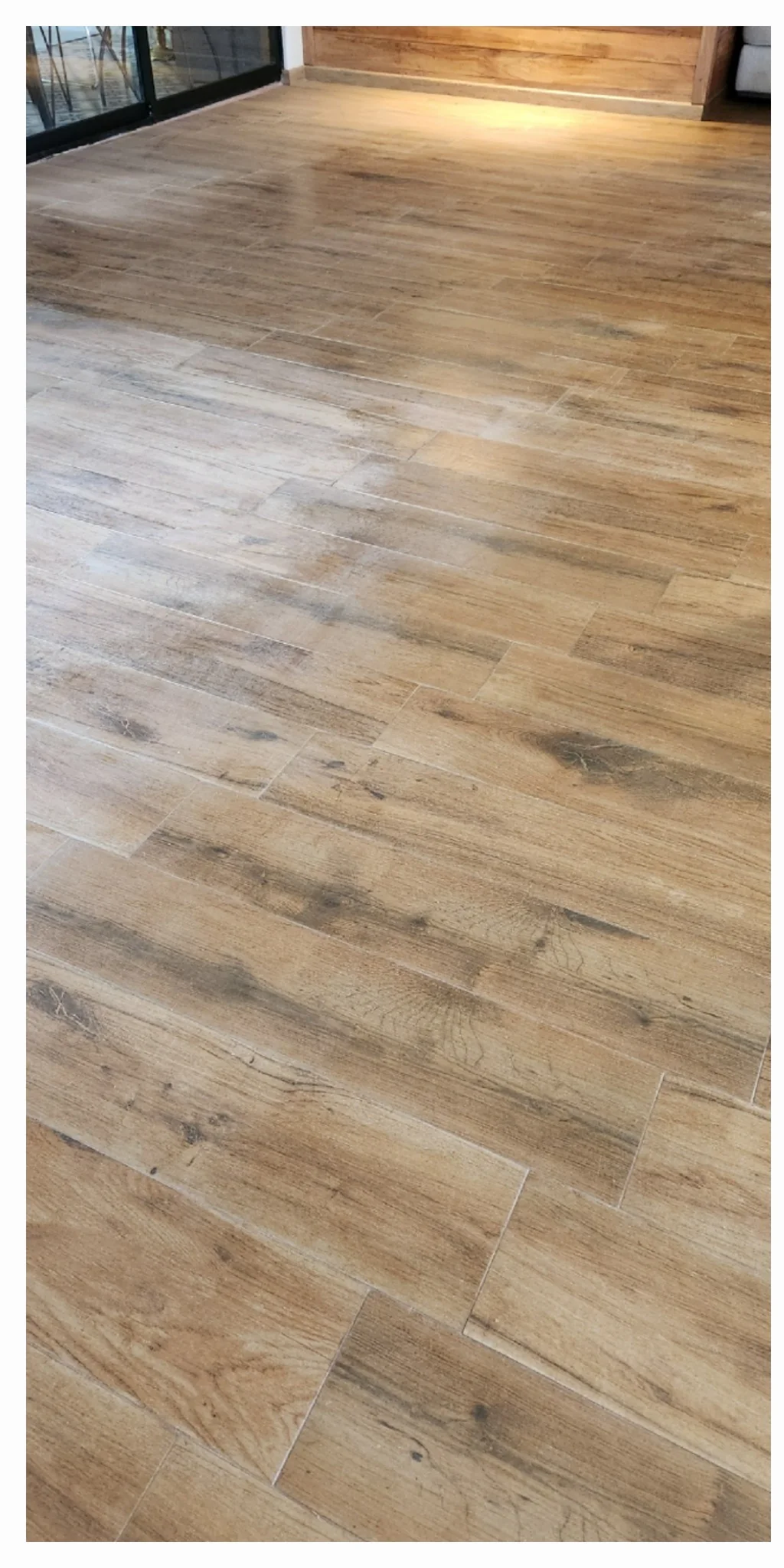Piso de porcelanato tipo madera con marcas visibles en una sala