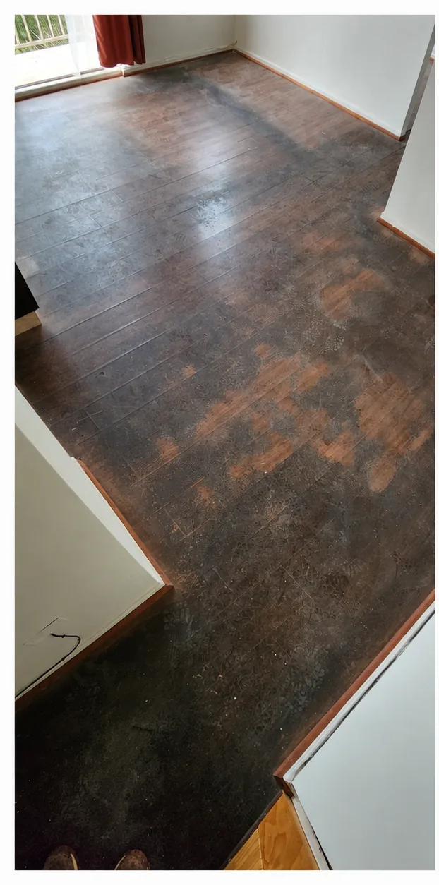 Piso flotante oscuro con zonas opacas antes del decapado