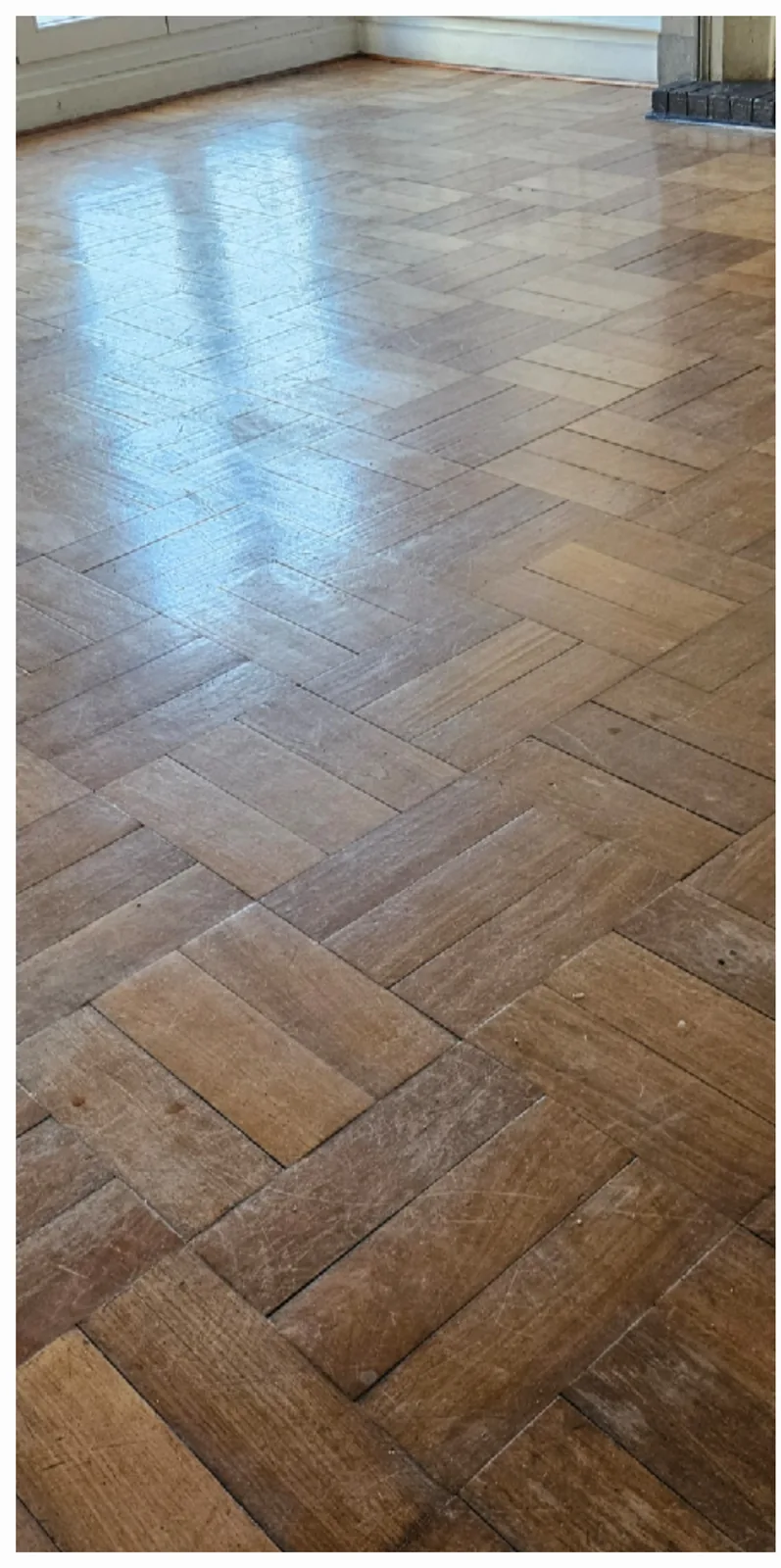 Piso de parquet con acabado oscuro y brillante antes del decapado