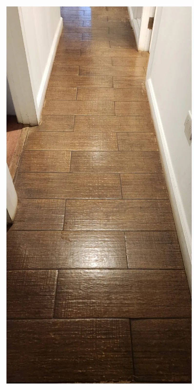 Piso de porcelanato de pasillo con acabado oscuro y brillante