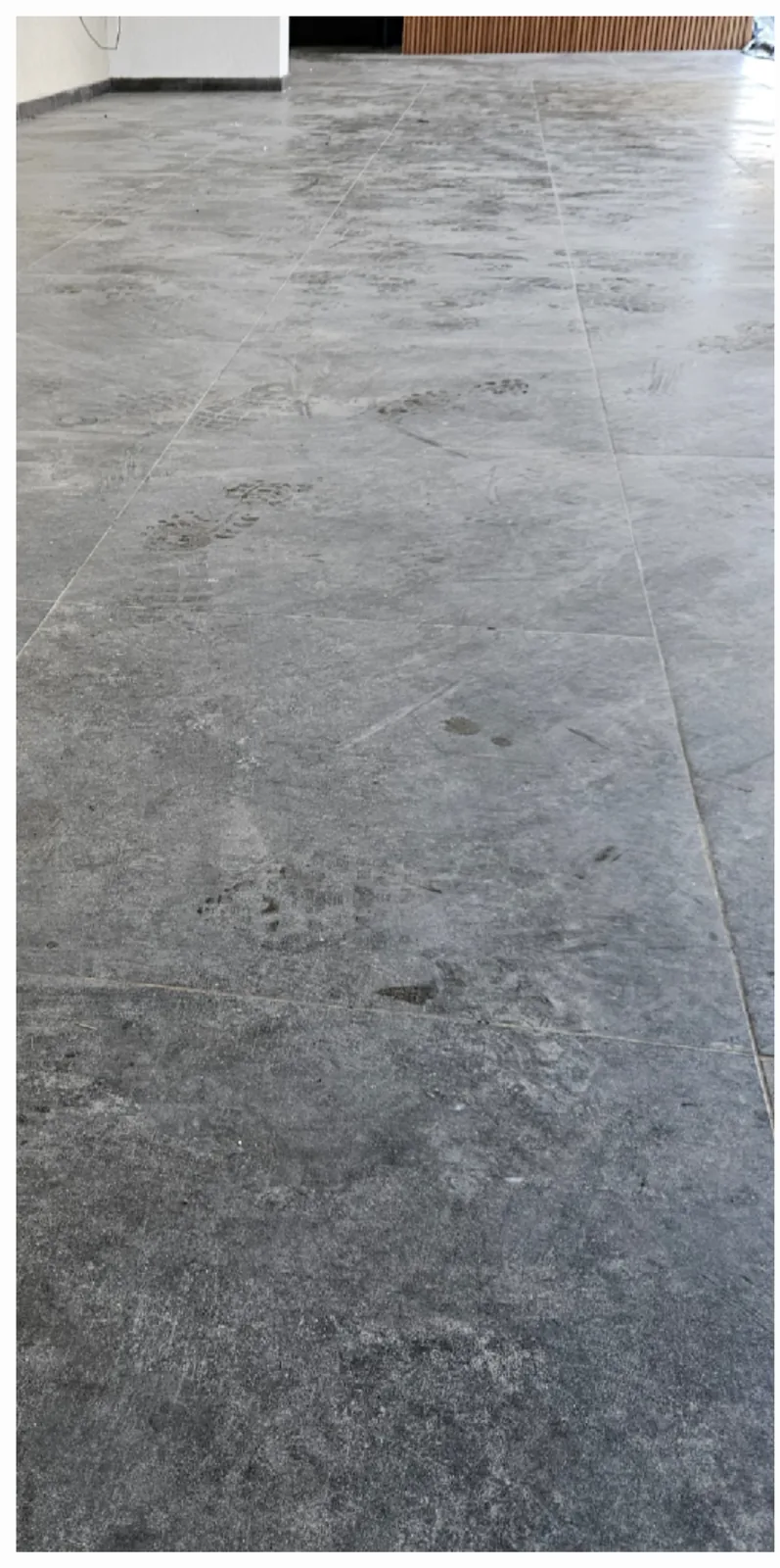Piso de baldosas grises cubierto de polvo de obra