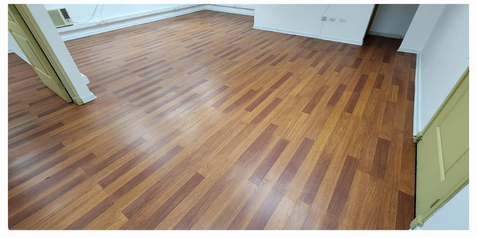 El mismo piso flotante después de la limpieza, con la superficie más clara y brillante