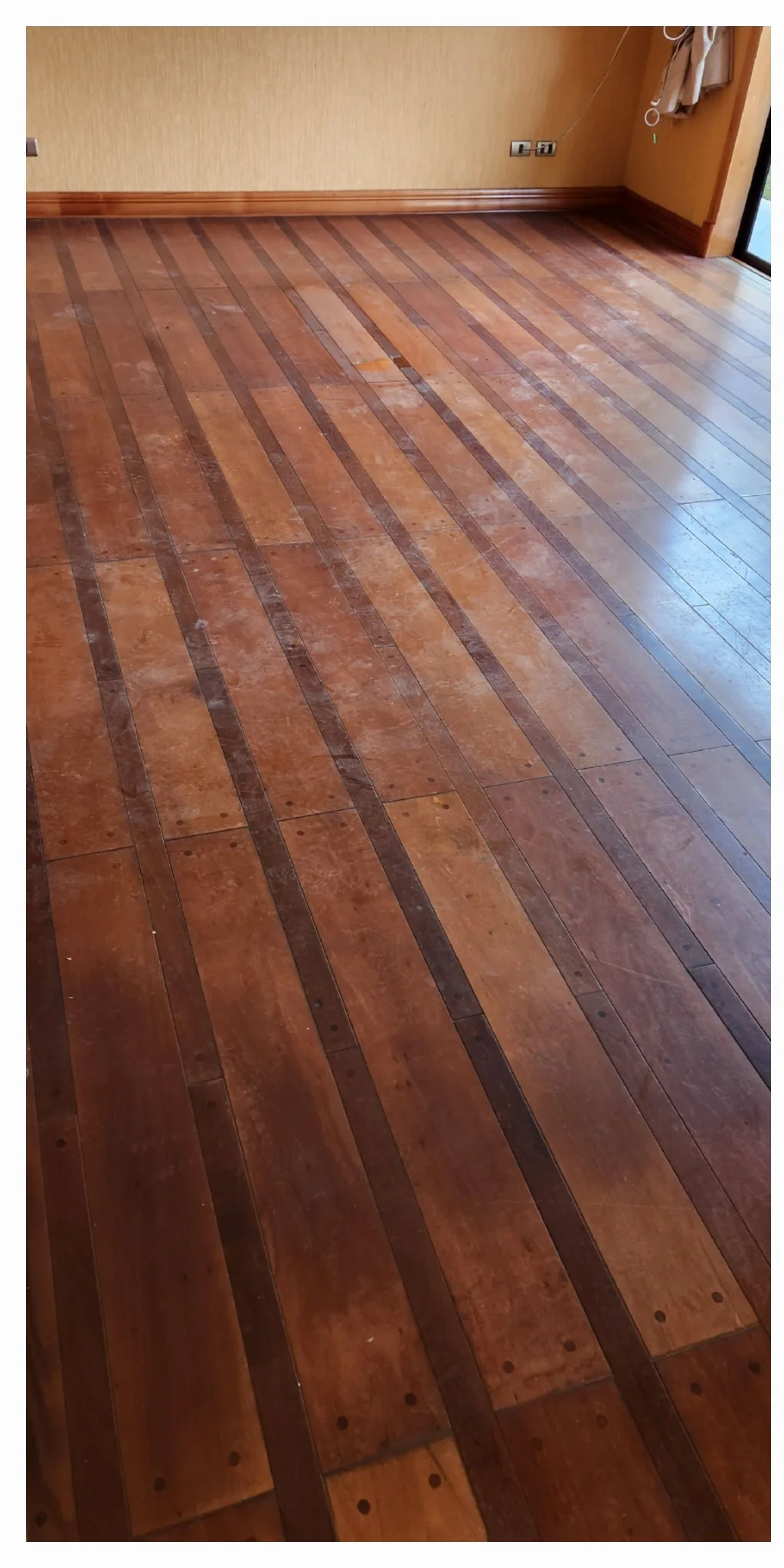 Piso de madera de habitación con zonas opacas y oscuras
