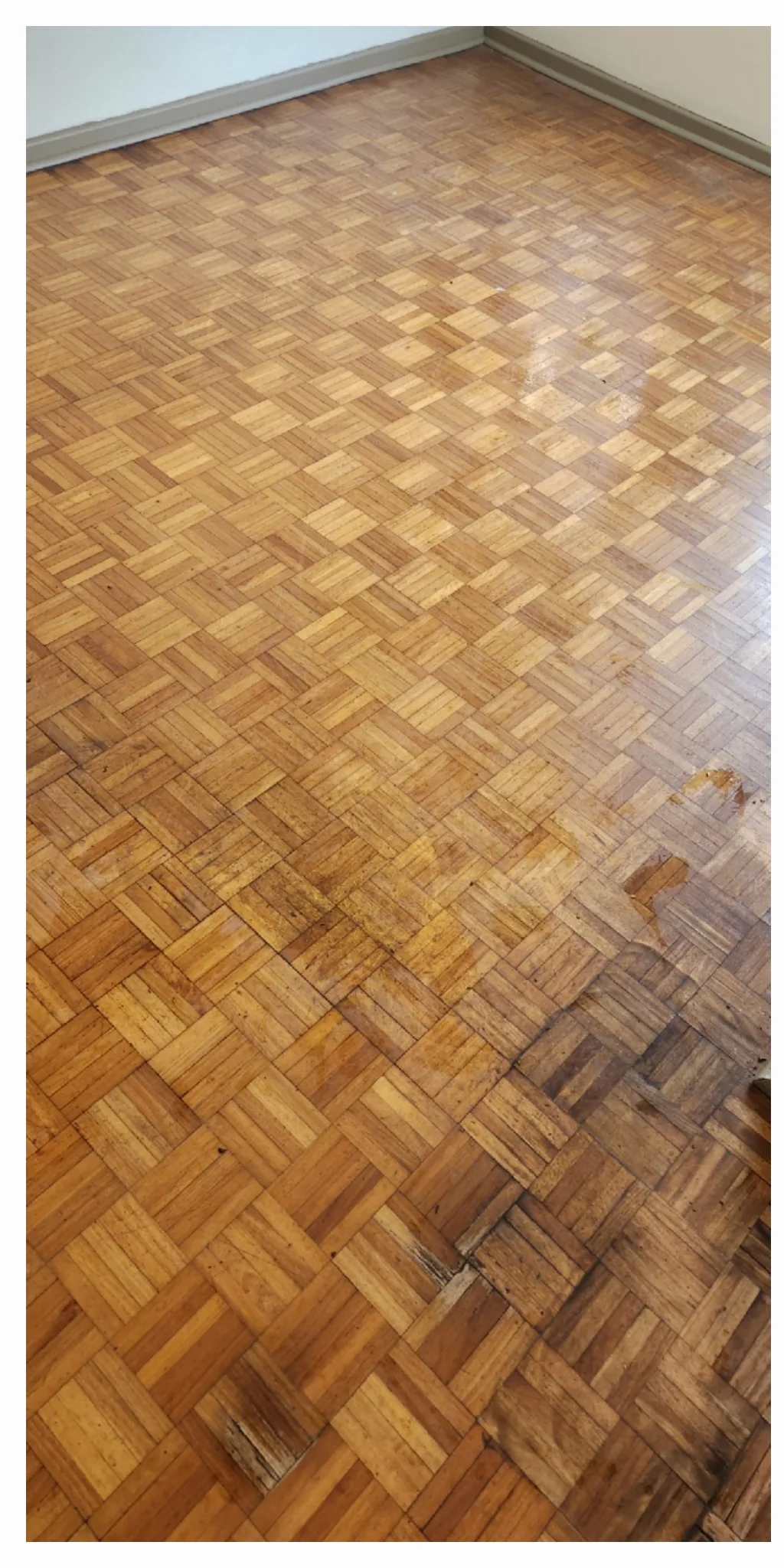 Parquet de tablillas con zonas oscuras y desgaste