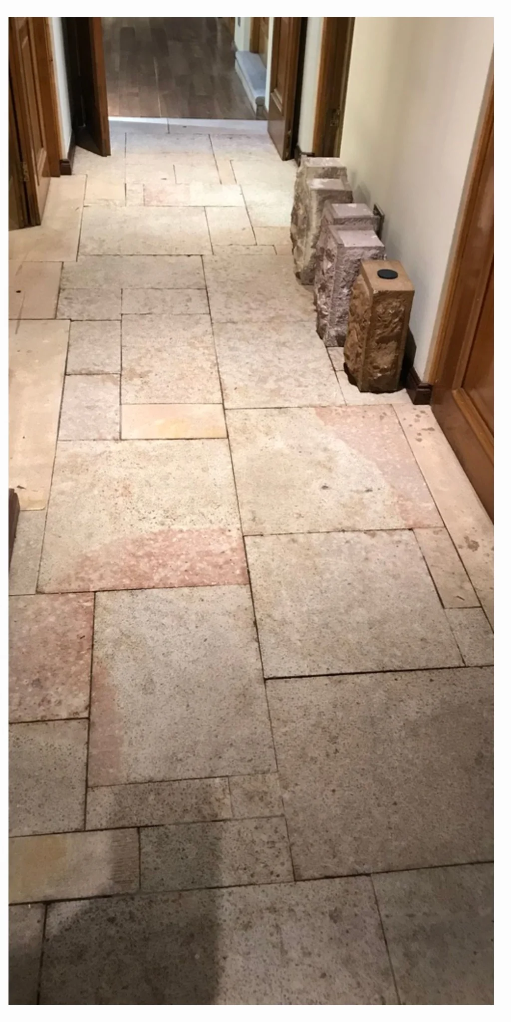 El mismo piso de piedra del pasillo con menos suciedad visible