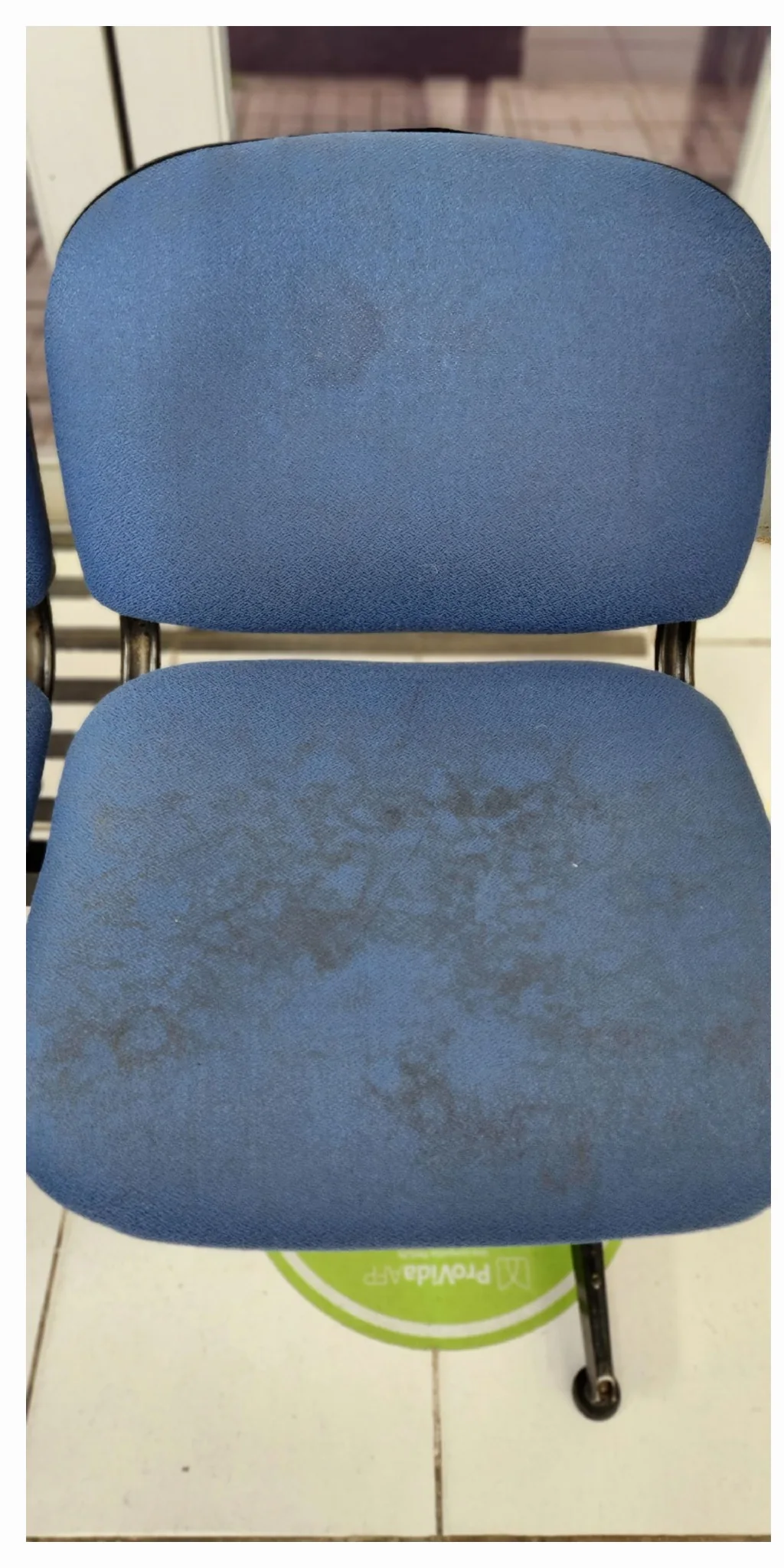 Asiento azul de silla de oficina con manchas oscuras