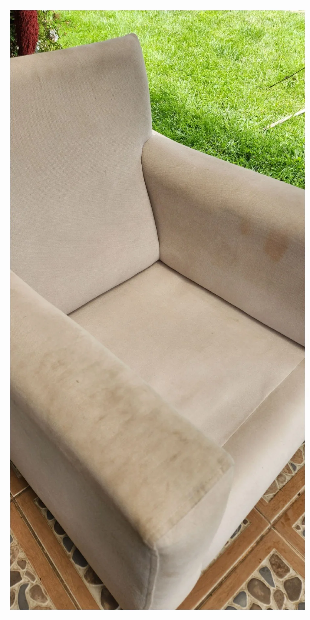 Sillón individual tapizado claro con marcas oscuras