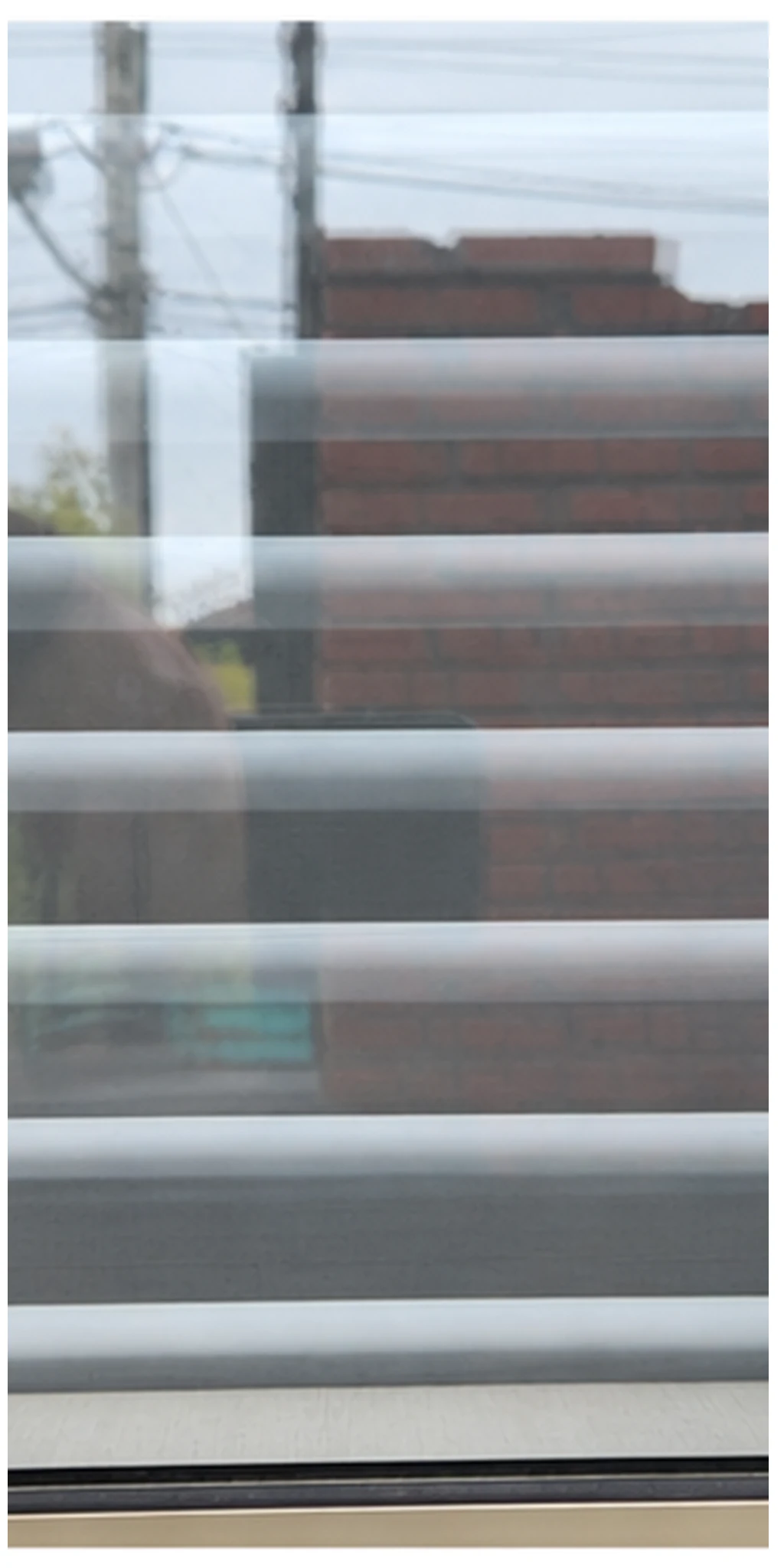La misma ventana con persiana y menos marcas de agua en el vidrio